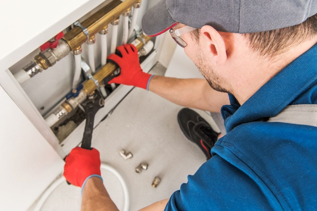 A plumber working on a hot water heater.